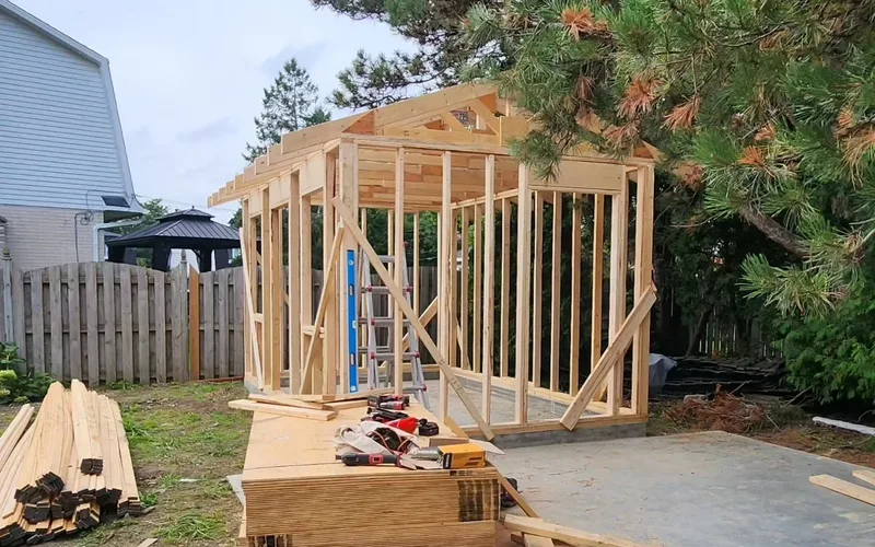 Detached backyard structure part-framed on a concrete slab in the GTA: stud walls up and roof framing started